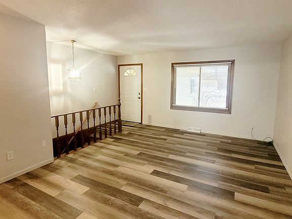 Living room upon entry with stairwell to basement level