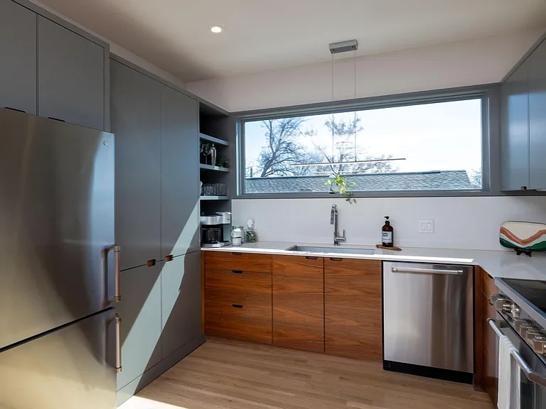 Compact kitchen fully stocked with all essentials and sleek stainless steel appliances_everything you need in a cozy space.