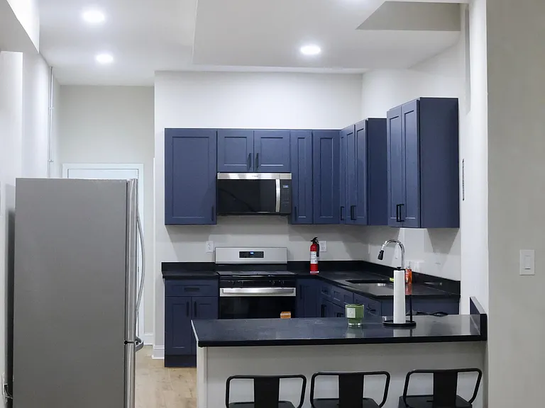 Kitchen with blue cabinets and black sparking quartz countertops