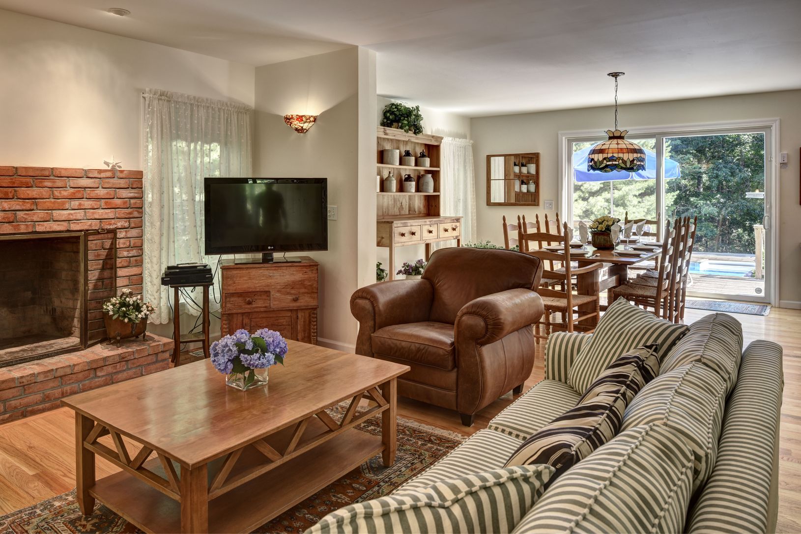  Bright and spacious living, dining area with view of the pool