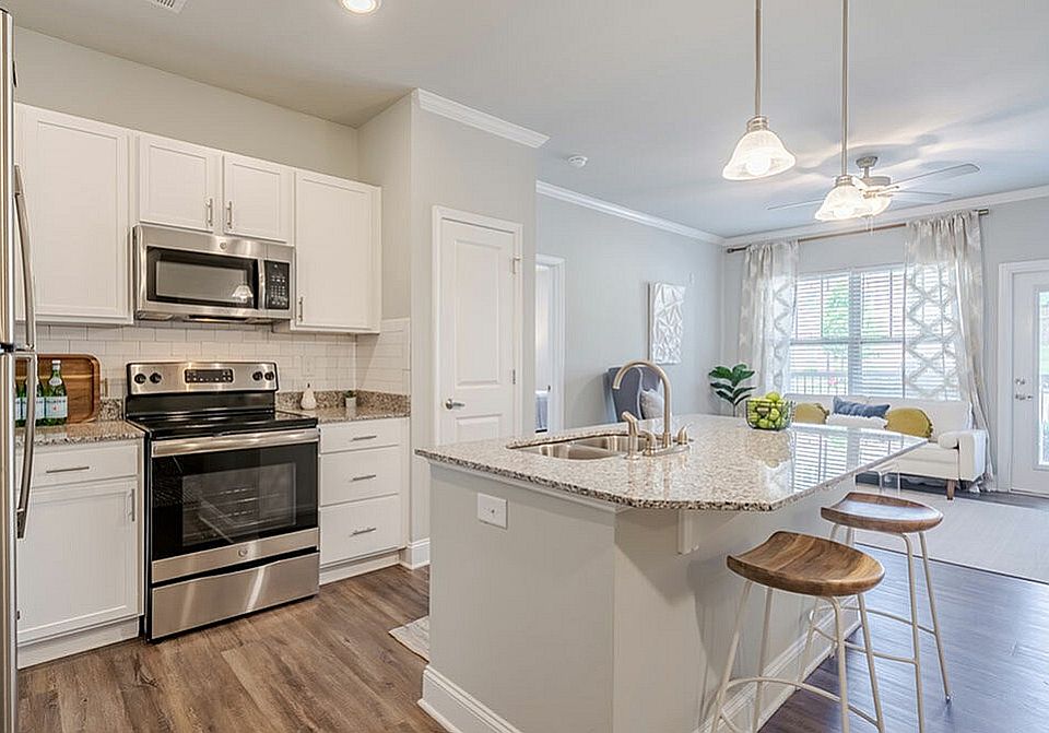 Experience the elegance of this modern kitchen, seamlessly connecting to a bright, airy living space.