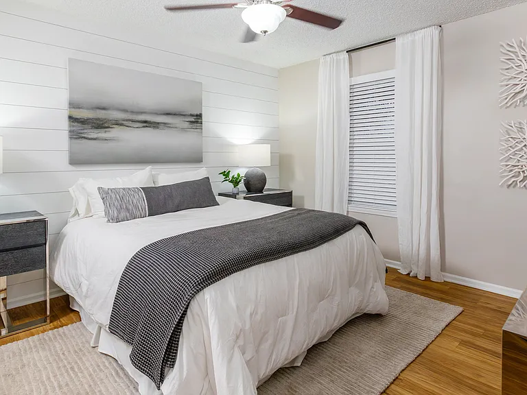 Spacious master bedroom featuring wood-style flooring, multi-speed ceiling fan, and a master bath.