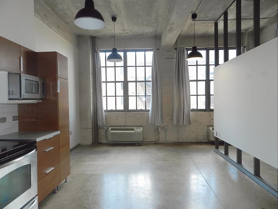 Living room & kitchen area with large windows. So much natural light!