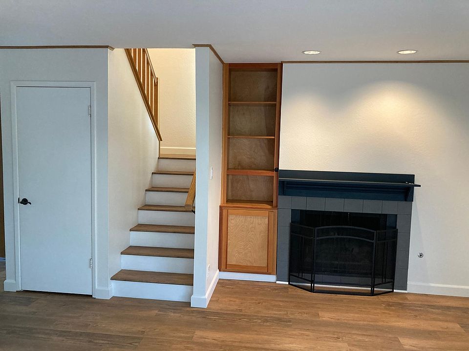 Living room with fireplace, custom built-in unit, WiFi enabled light switch, and large coat/storage closet.