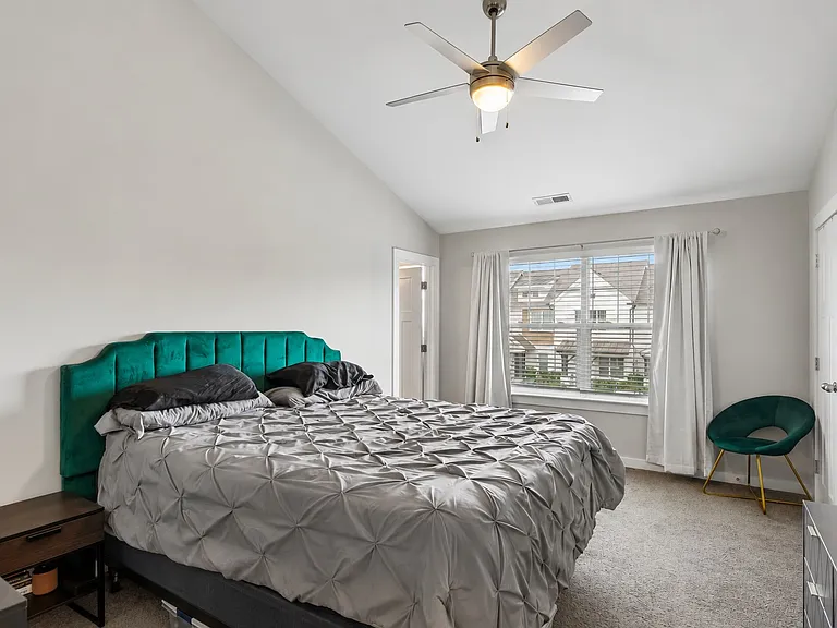 Spacious primary suite with vaulted ceiling, large windows, and generous closet space.