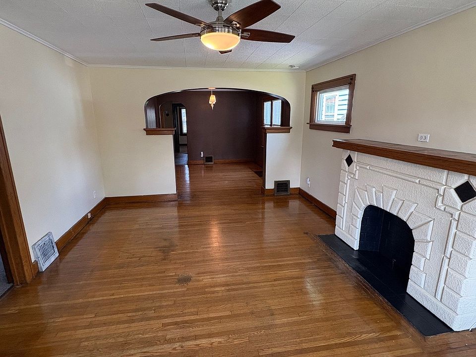 Living room with ceiling fan, NON-WORKING fireplace mantel, fresh paint.