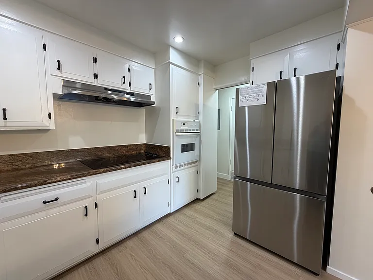 Kitchen with Granite Counter, Smooth Cooktop, & Large Stainless Steel Fridge