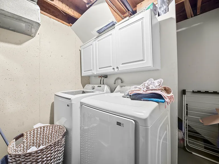 Dedicated laundry room with a less than 3-year-old Samsung washer and dryer, built-in cabinets, and additional storage space for added convenience.
