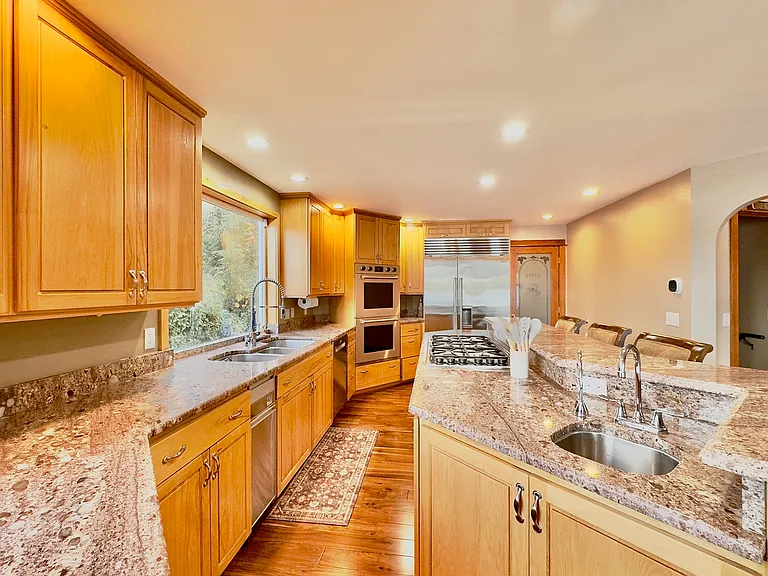 The chef's kitchen, complete with premium appliances and wine fridge, makes entertaining effortless. Guests can gather around the dining table or cozy up by the gas fireplace, all while enjoying radiant floor heating.