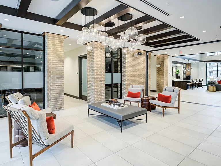 Stylish Resident Lounge with Natural Brick Columns and Pendant Lighting