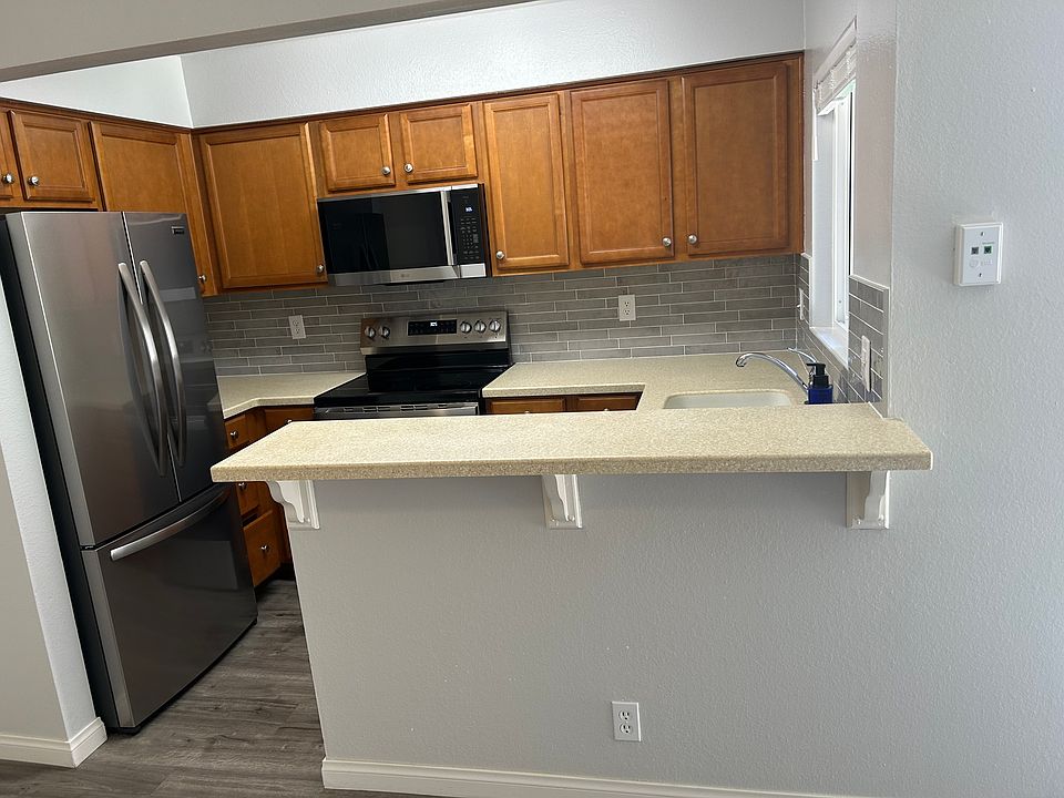 Kitchen with new stainless steel appliances and backsplash.