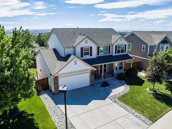 Inviting front porch and double-door entry into vaulted foyer.