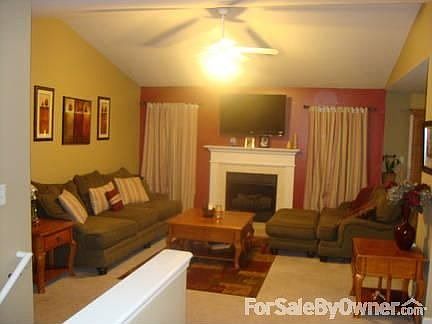 Living room with vaulted ceilings and opens to formal dining and eat-in kitchen