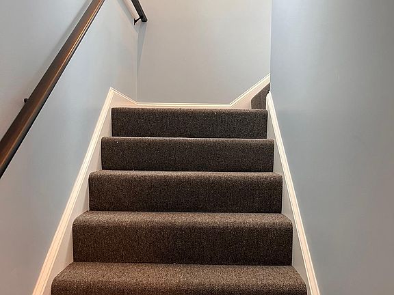 carpeted hallway stairs to second floor apartment.
