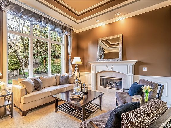 Formal living features high, tray ceiling and is anchored by gas fireplace.