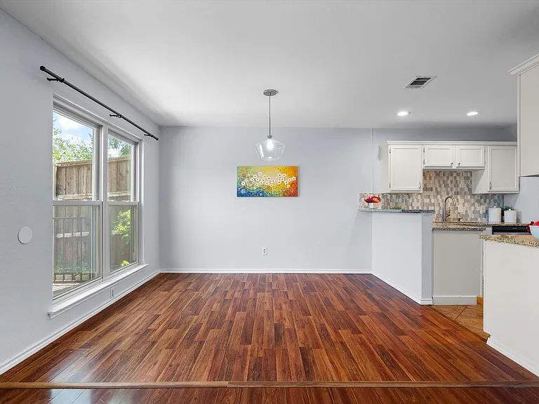 The bright windows look over the back yard and deck.