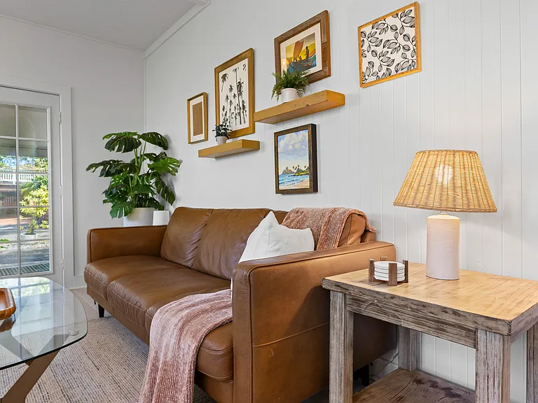The living room includes an Italian leather sofa and loveseat and one chair, TV, ceiling fan, windows and an AC unit. The living room opens to the lanai and blends seamlessly with the kitchen.