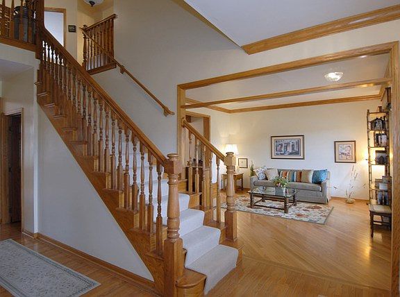 Foyer with Hardwood Flooring, features a Custom Oak Staircase