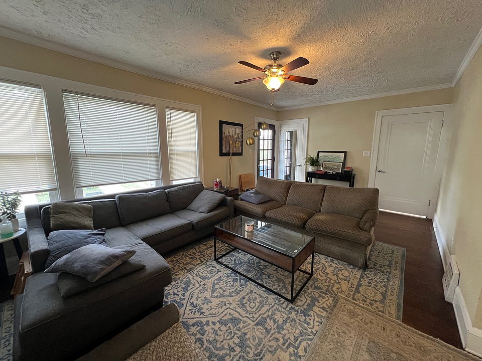 Living Room (with hardwood flooring) with views of the unit entrance and access to covered outdoor porch.