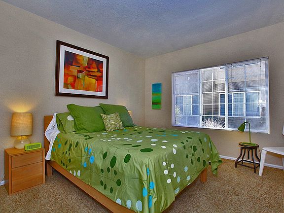 Model apartment, showing the bedroom with a bed, and plush carpeting.