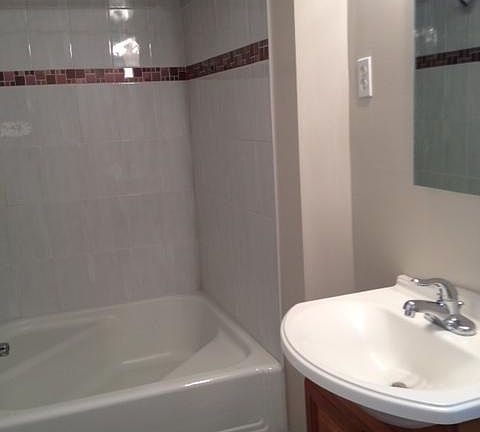 Odd shaped square bathtub and shower.