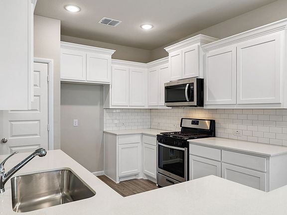 Kitchen in the Sapphire home plan by Trophy Signature Homes - REPRESENTATIVE PHOTO