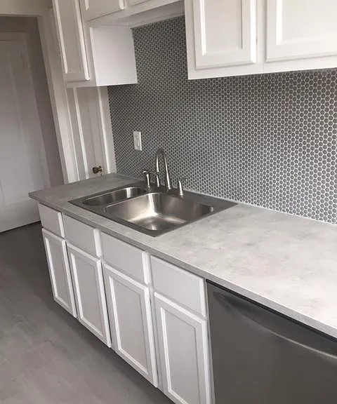 Stunning kitchen with laminate flooring, backsplash, and dishwasher