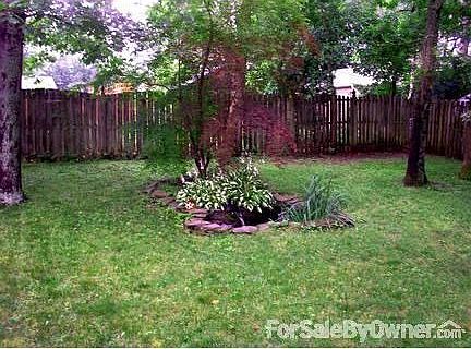 Landscaped pond : Tranquil koi pond with running fountain and lush vegetation accents back yard.