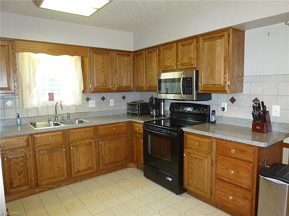 UPDATED KITCHEN OFFERS BUILT IN MICROWAVE, STOVE, REFRIGERATOR, DISPOSAL AND DOUBLE STAINLESS STEEL SINKS
