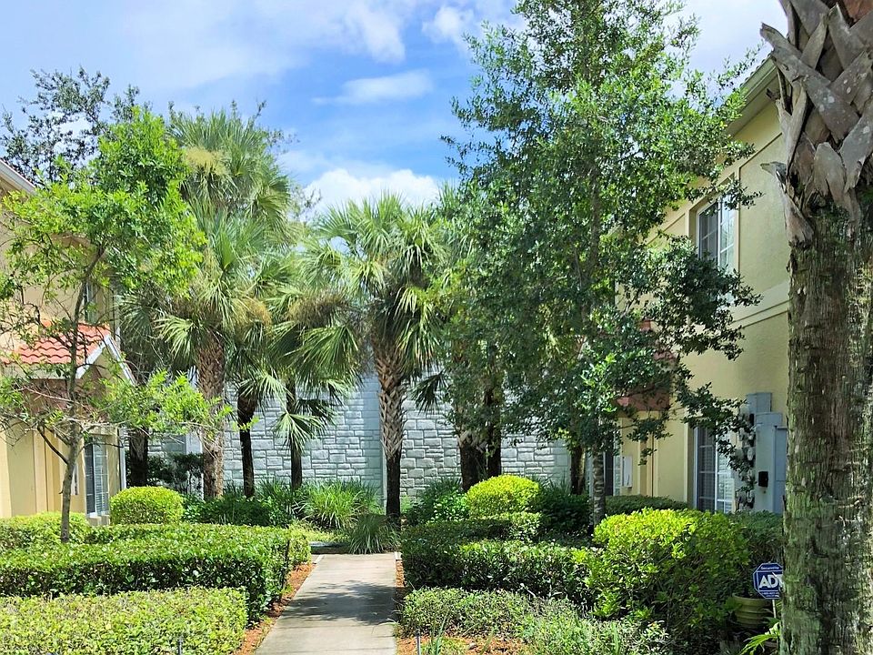 A short path leads through a lushly landscaped courtyard to
