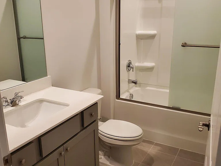 Full bath downstairs with frosted glass shower door