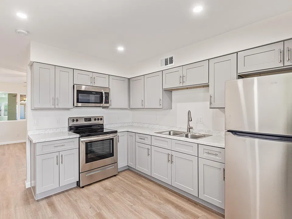 View of kitchen from dining area. Living room is just past the kitchen and behind us is the door to the backyard.
