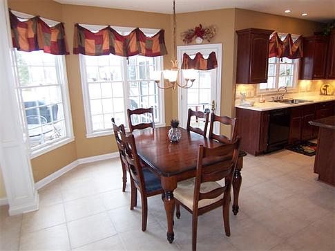 Bright cheery breakfast room with a door to the screened porch
