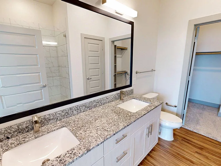 Apartment Bathroom with double mirror and Wood Style Flooring.