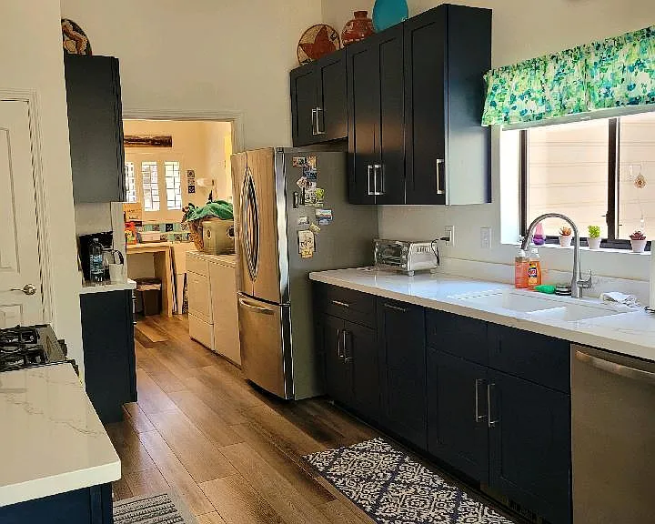 New refrigerator with ice maker and coffee counter on left, looking into laundry room and door to garage