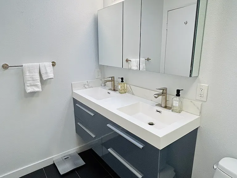 Dual sinks with lots of storage space in the vanity and mirror that opens for more storage
