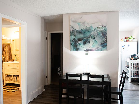 dining area with kitchen to one side, hallway to linen closet, 1 bedroom and additional storage closet, hall to bathroom, laundry and second bedroom to the left.