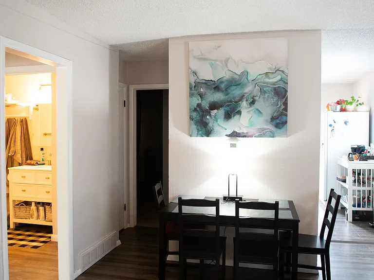 dining area with kitchen to one side, hallway to linen closet, 1 bedroom and additional storage closet, hall to bathroom, laundry and second bedroom to the left.