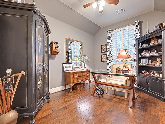 Home office with vaulted ceilings and plantation shutters.