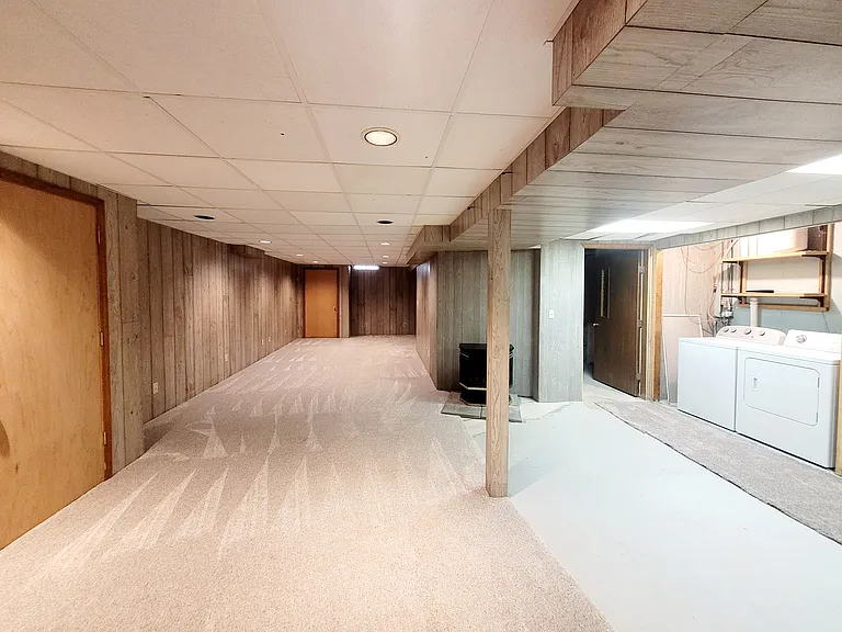Partially finished basement level with second living/recreational area and laundry closet
