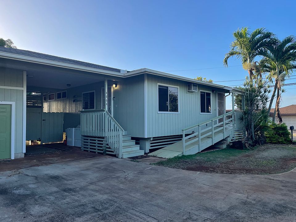 Covered parking area with washer and dryer and the two entrances into the house.