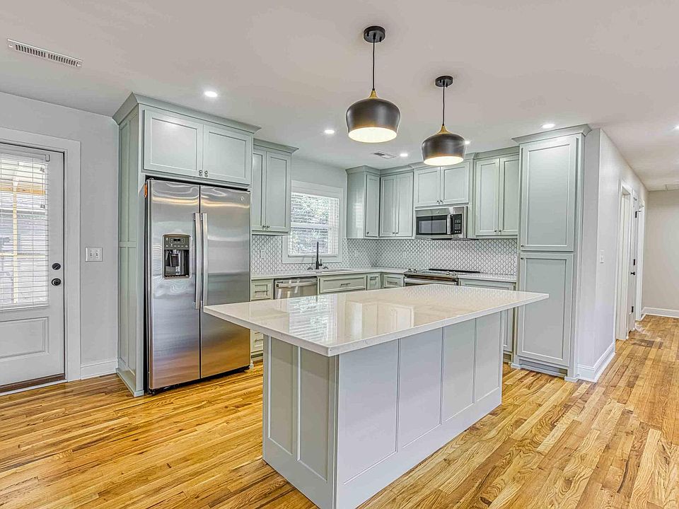 Custom cabinetry and large island. Door to the screened-in back porch next to the kitchen