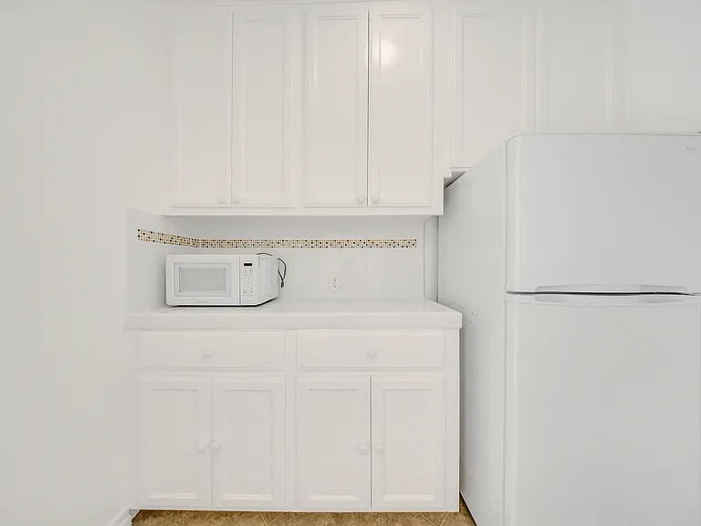Kitchen area with large refrigerator and microwave