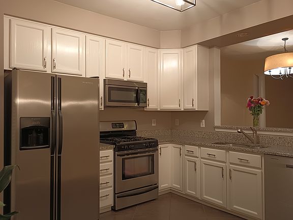 Beautiful bright kitchen features stainless steel appliances, granite countertops, and updated lighting!