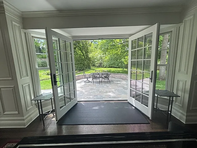 Double french doors open to bluestone patio.