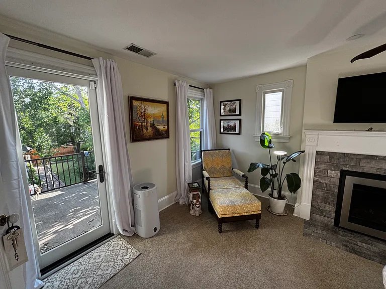Primary bedroom and balcony, with gas fireplace.