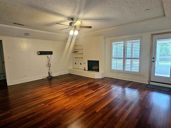 Living room featuring hardwood floors and a wood burning fireplace