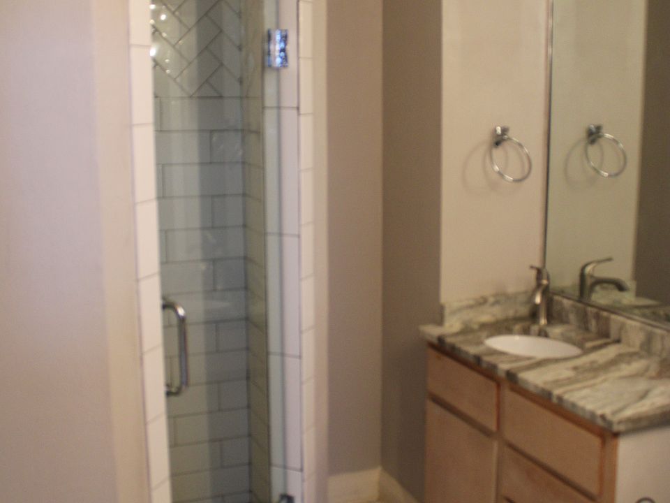 Bathroom with large shower, vanity and toilet.