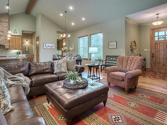 The entry opens into the open and flowing floor plan that is ideal for entertaining. The living room boasts a soaring high 16' cathedral ceiling, engineered hard wood flooring, a toasty gas log fireplace, and large windows that let in plenty of natur