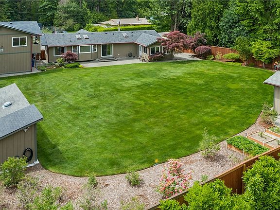 No need to venture out when you can play & relax in this park like setting! Exercise your green thumb in the raised garden beds & a blueberry patch. There's space to pop in a pool & play toys too 